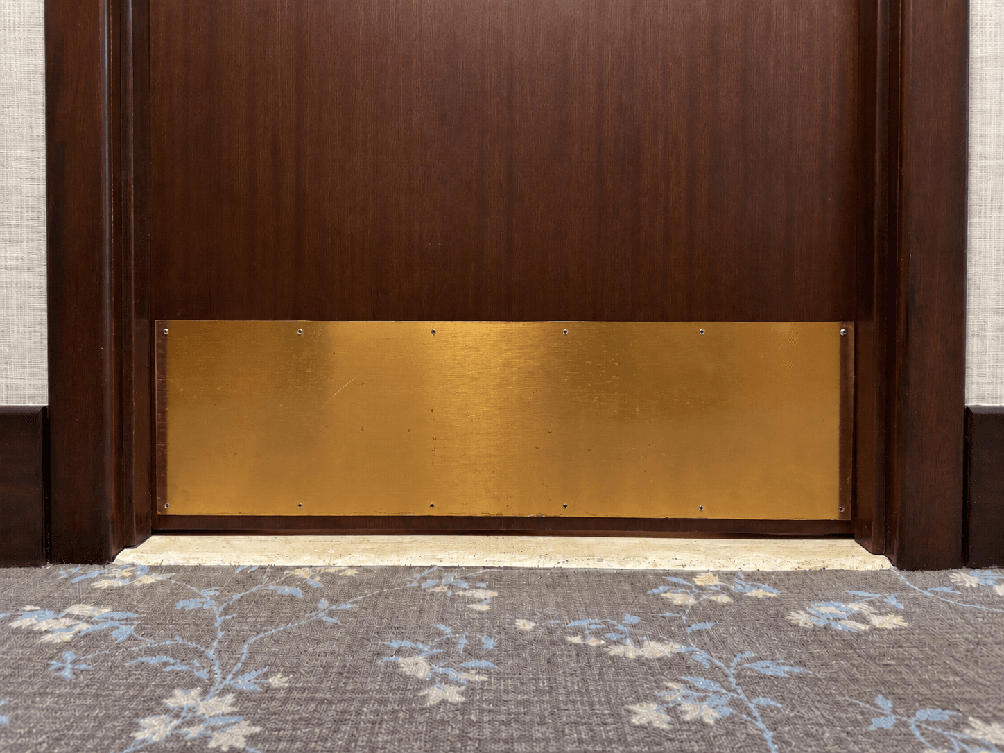 Worn brass kick plate before refinishing