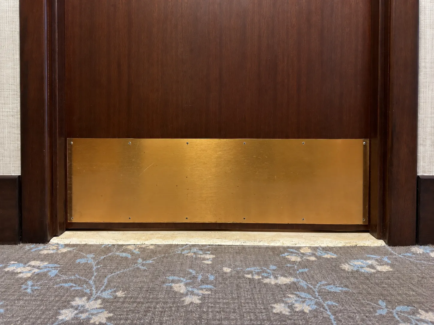 Worn brass kick plate before refinishing